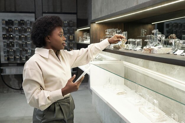 Jeune vendeuse avec assortiment de contrôle de tablette