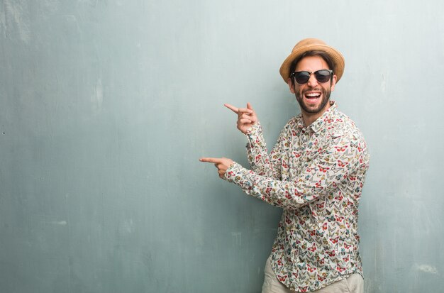 Jeune voyageur portant une chemise colorée pointant vers le côté