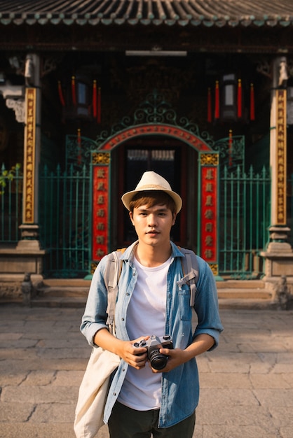 Jeune voyageur prenant des photos de la ville antique dans le style asiatique