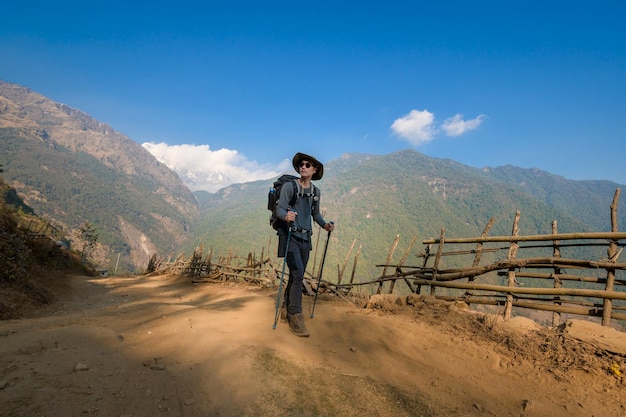 Un jeune voyageur trekking sur piste forestière Népal