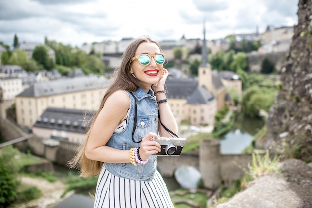 Jeune voyageuse avec photocamera profitant d'une belle vue sur le paysage urbain de la vieille ville de Luxembourg-ville