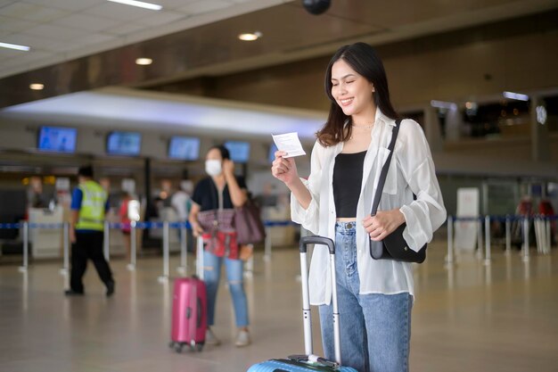 Jeune voyageuse transportant des valises à l'aéroport international