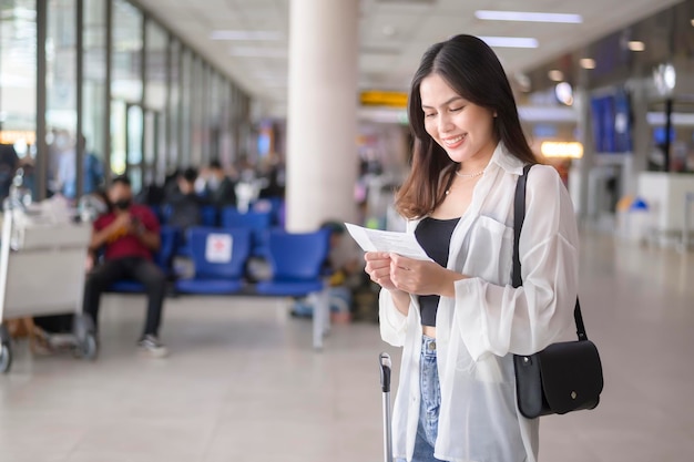 Jeune voyageuse transportant des valises à l'aéroport international