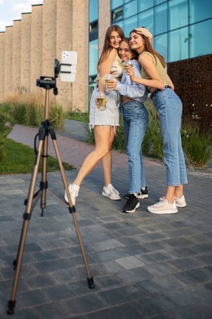 Photo jeunes adolescentes enregistrant des bobines d'elles-mêmes à l'extérieur pour les médias sociaux