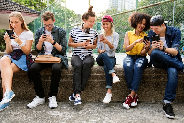 Jeunes Adultes Amis à L'aide De Smartphones Ainsi Que Le Concept De Culture De Jeunes à L'extérieur