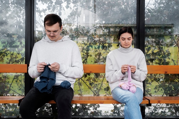 Photo jeunes adultes tricotant à l'extérieur