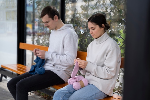 Photo jeunes adultes tricotant à l'extérieur