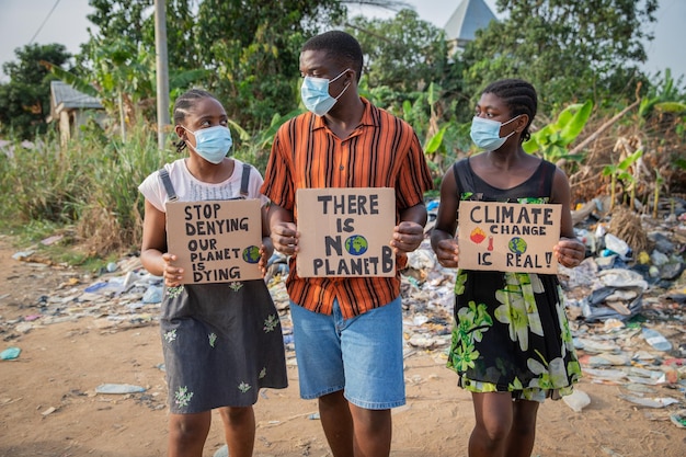 Jeunes africains protestant contre le changement climatique tenant des pancartes et portant des masques