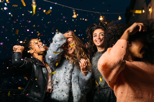 De jeunes amies qui profitent d'une fête la nuit.