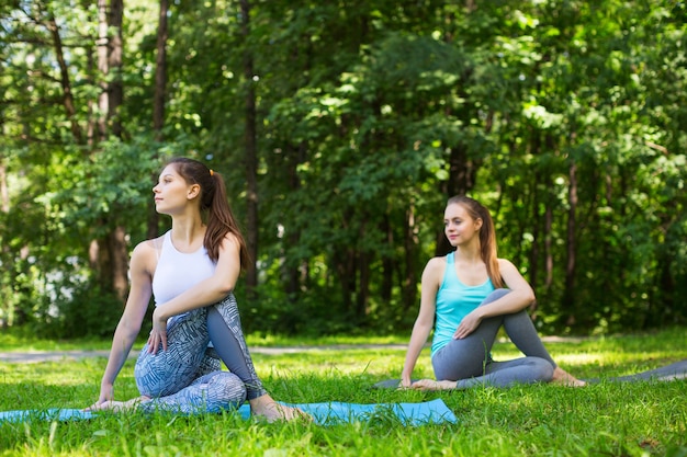 Jeunes amies travaillant et faisant du yoga en plein air