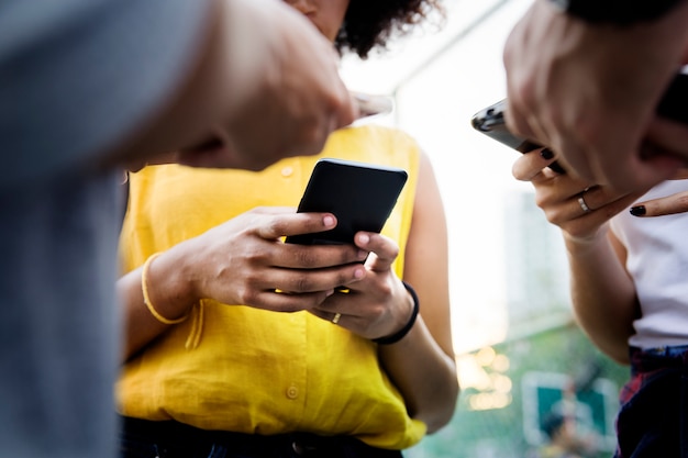 Jeunes amis adultes à l&#39;aide de smartphones à l&#39;extérieur