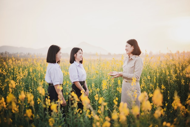 Jeunes amis asiatiques dans un champ de fleurs de crotalaria