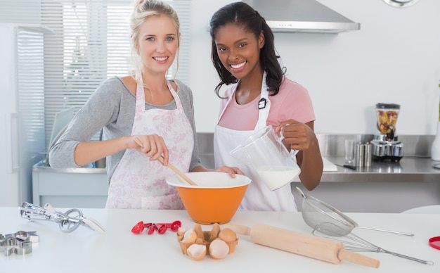 Photo jeunes amis faisant la pâtisserie ensemble en regardant la caméra