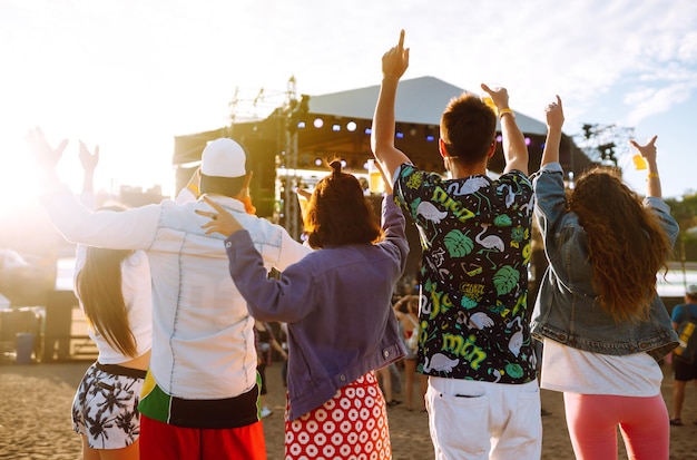 Jeunes amis heureux buvant de la bière et s'amusant ensemble au festival de musique Amitié