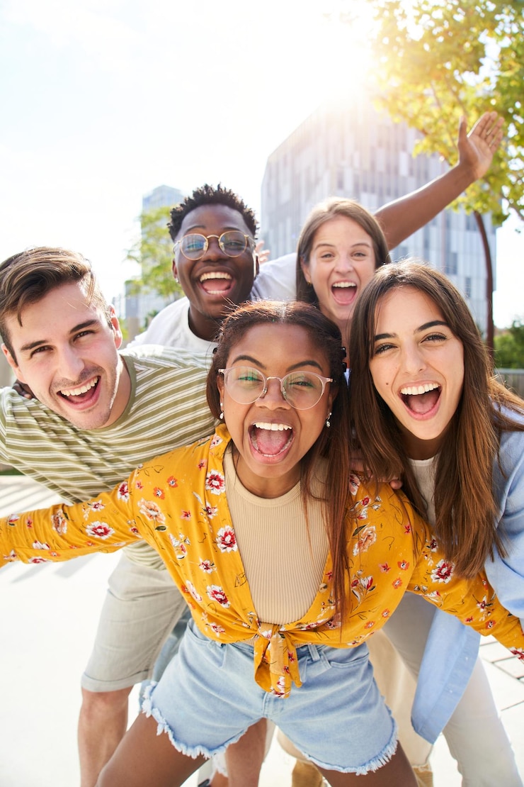 Photo de jeunes amis heureux regardant la caméra et riant un groupe de personnes souriantes s'amusant ensemble à l'extérieur