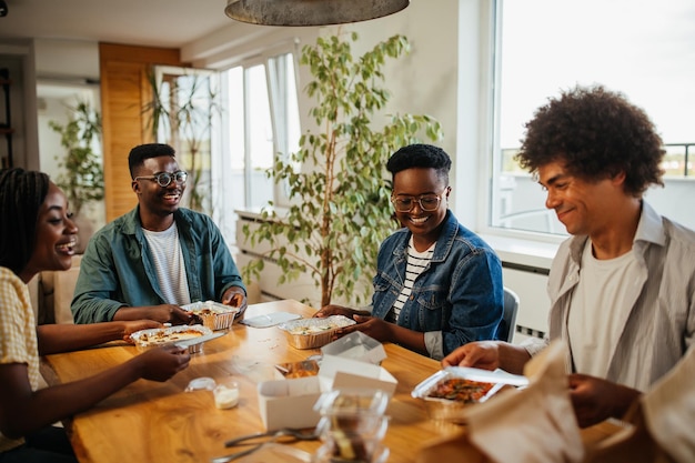 Jeunes amis heureux s'amusant pendant l'heure du déjeuner à la maison