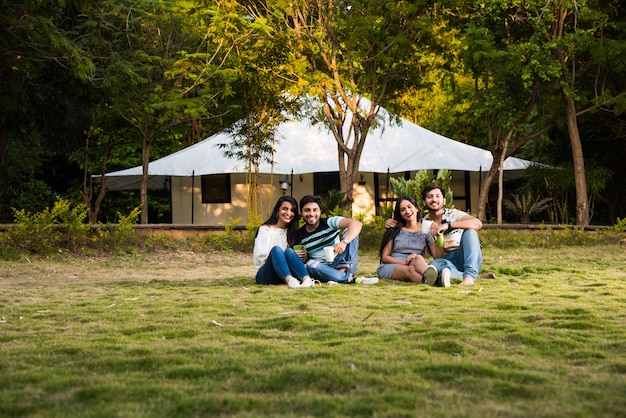 De jeunes amis indiens asiatiques passent du bon temps en camping, des vacances relaxantes avec des tentes amusantes à l'extérieur