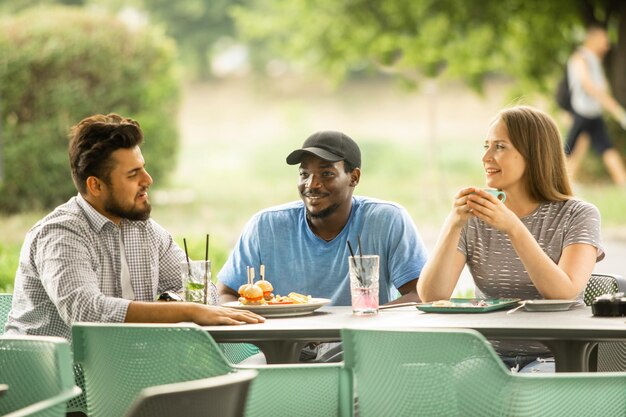 Jeunes amis joyeux s'amusant tout en parlant dans un café