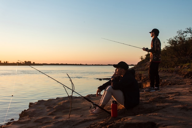 Jeunes amis pêchant et se relaxant au bord de la rivière.