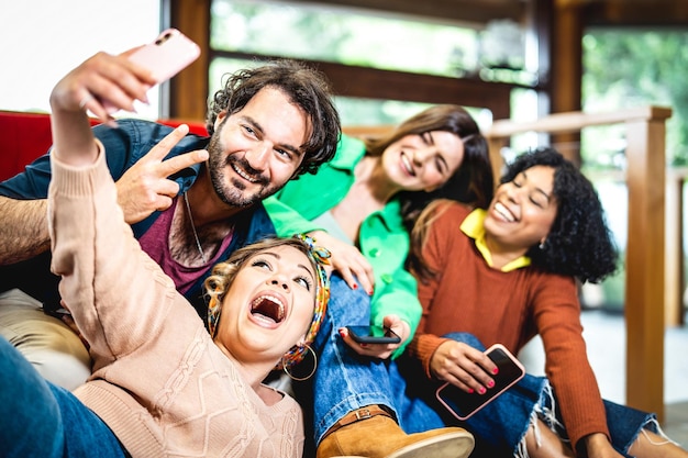 Photo jeunes amis s'amusant ensemble à la maison en prenant un selfie drôle ensemble concept de style de vie d'étudiants confortables avec des gens heureux colocataires se relaxant sur un canapé filtre vif et lumineux