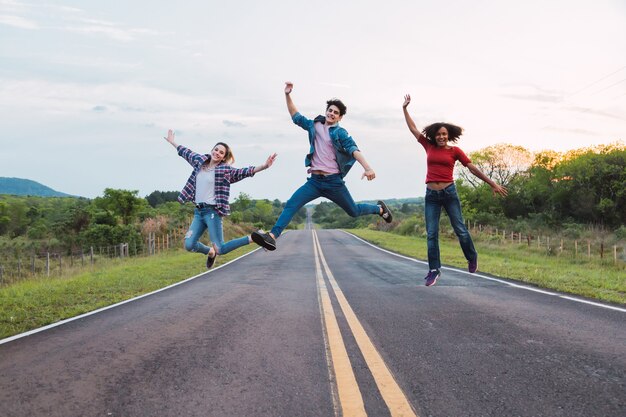 Jeunes amis sautant sur la route