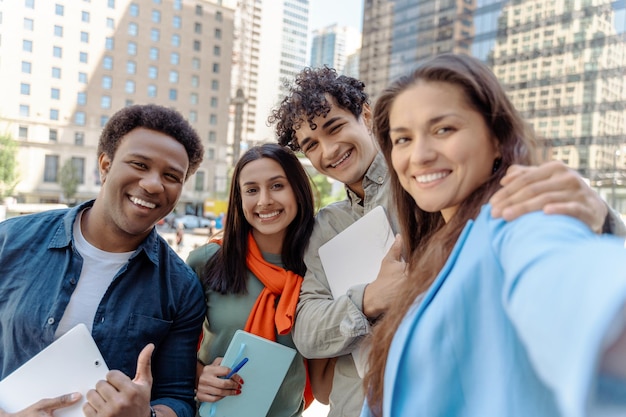 Jeunes amis souriants prenant un selfie regardant la caméra dans la rue