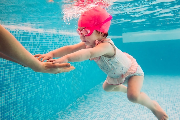 Jeunes amis sous l'eau dans la piscine