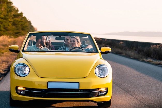 Les jeunes amis voyagent en cabriolet jaune