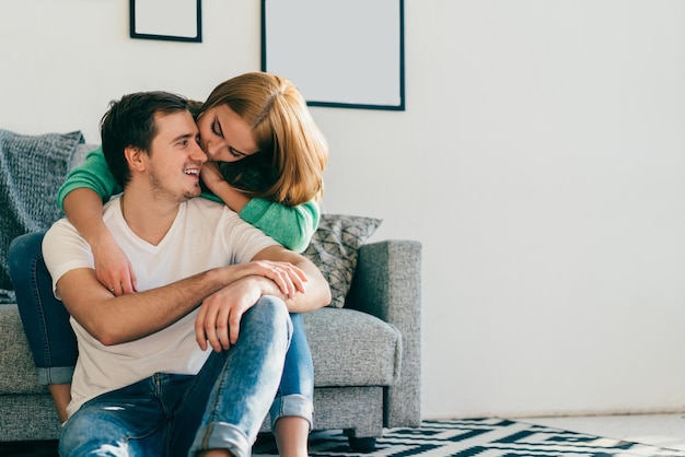 Jeunes amoureux ayant un moment romantique assis sur un canapé