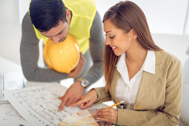 De jeunes architectes qui réussissent discutent des plans de construction et planifient ce qu'il faut changer pour être meilleurs. Ils sont au bureau.