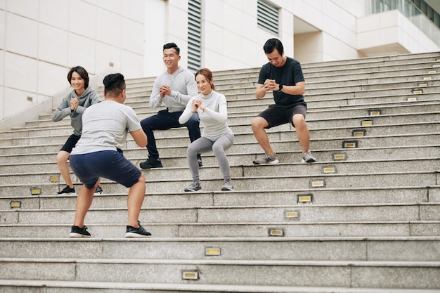 Les jeunes asiatiques répètent après l'entraînement et font des squats pour renforcer les jambes et les muscles abdominaux