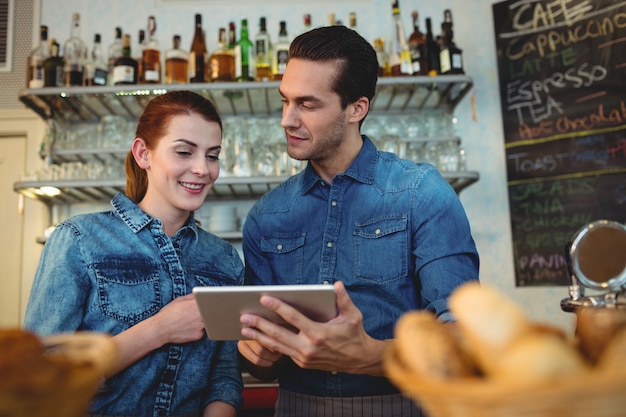 Jeunes baristas avec tablette numérique au café