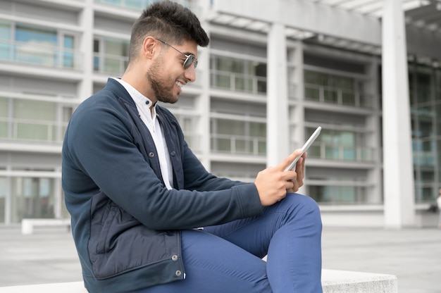 Jeunes beaux hommes utilisant un smartphone dans la ville souriant jeune homme envoyant des SMS sur son téléphone portable café...