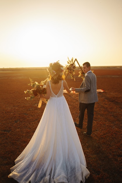 Jeunes et beaux mariés s'amusent. Jour de mariage dans un style bohème.