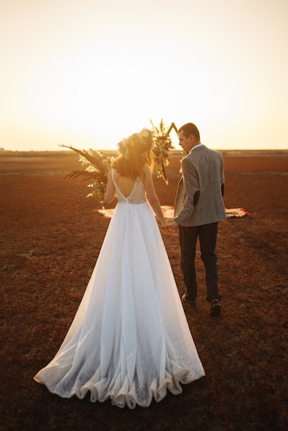 Jeunes et beaux mariés s'amusent. Jour de mariage dans un style bohème.