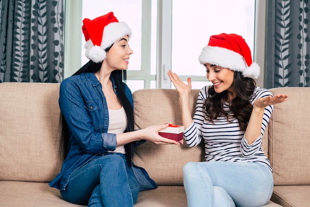 Jeunes belles femmes heureux en chapeaux de Santa