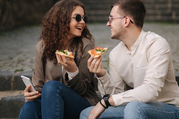 Les jeunes blogueurs font selfie avec une tranche de pizza dans les mains