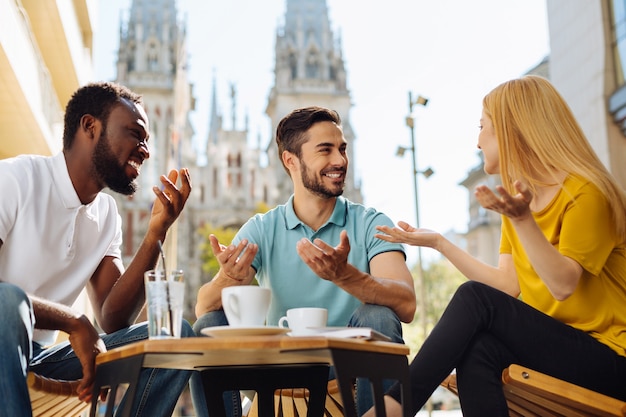 Jeunes charismatiques discutant et s'amusant au café