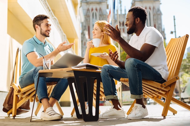 Jeunes charismatiques discutant et s'amusant au café