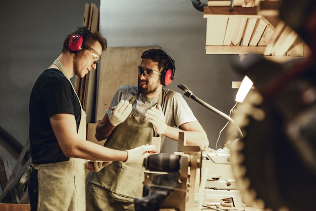 Jeunes charpentiers parlant près de l'établi