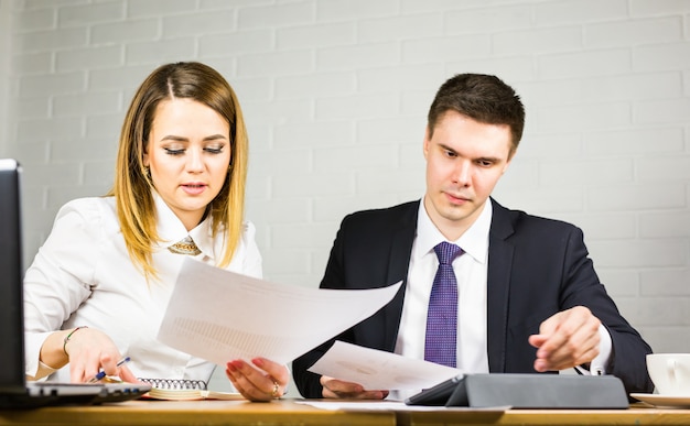 Jeunes collègues de travail discuter du travail sur un ordinateur portable dans l'espace de co-travail, les gens d'affaires d'entreprise