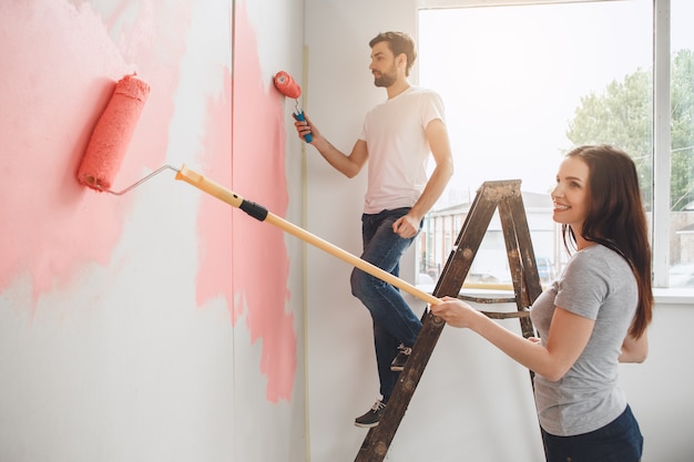 Jeunes couples faisant la réparation d'appartement ensemble eux-mêmes