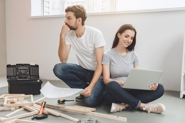 Jeunes couples faisant la réparation d'appartement ensemble eux-mêmes