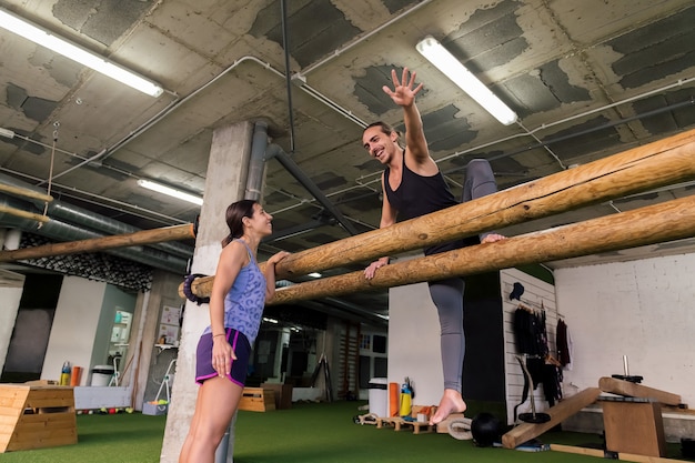 Les jeunes couples sportifs font la formation fonctionnelle au gymnase