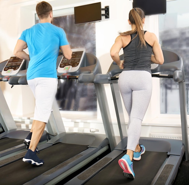 Jeunes courant sur des tapis roulants dans la salle de gym