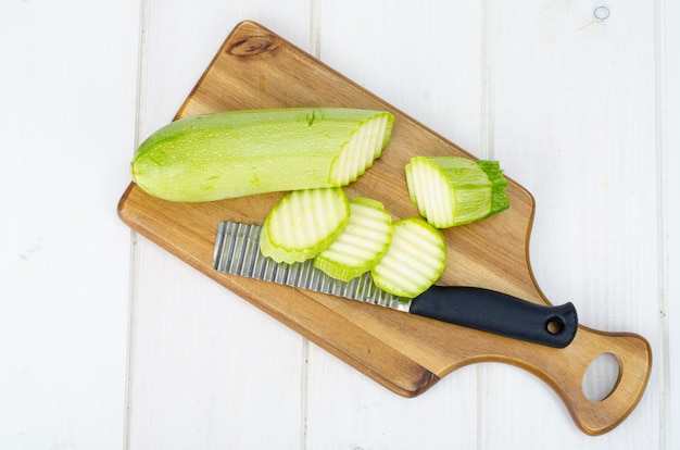 Jeunes courgettes fraîches vertes sur une table en bois pour la cuisson