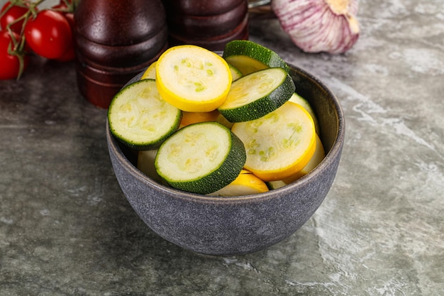 Jeunes courgettes vertes et jaunes crues en tranches pour la cuisson