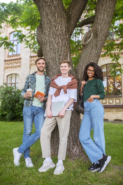 Les jeunes debout près de l'arbre dans le parc