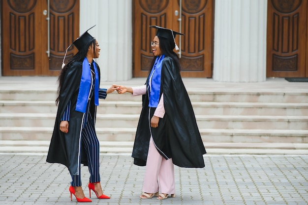 Jeunes Diplômés Debout Devant Le Bâtiment De L'université Le Jour De La Remise Des Diplômes