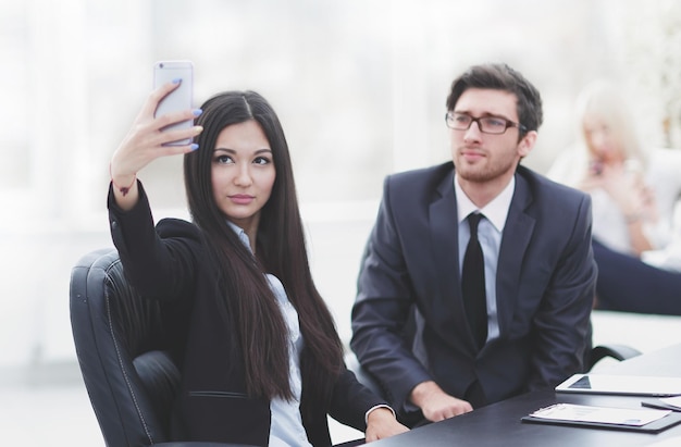 Les jeunes employés prennent des selfies à leur bureau